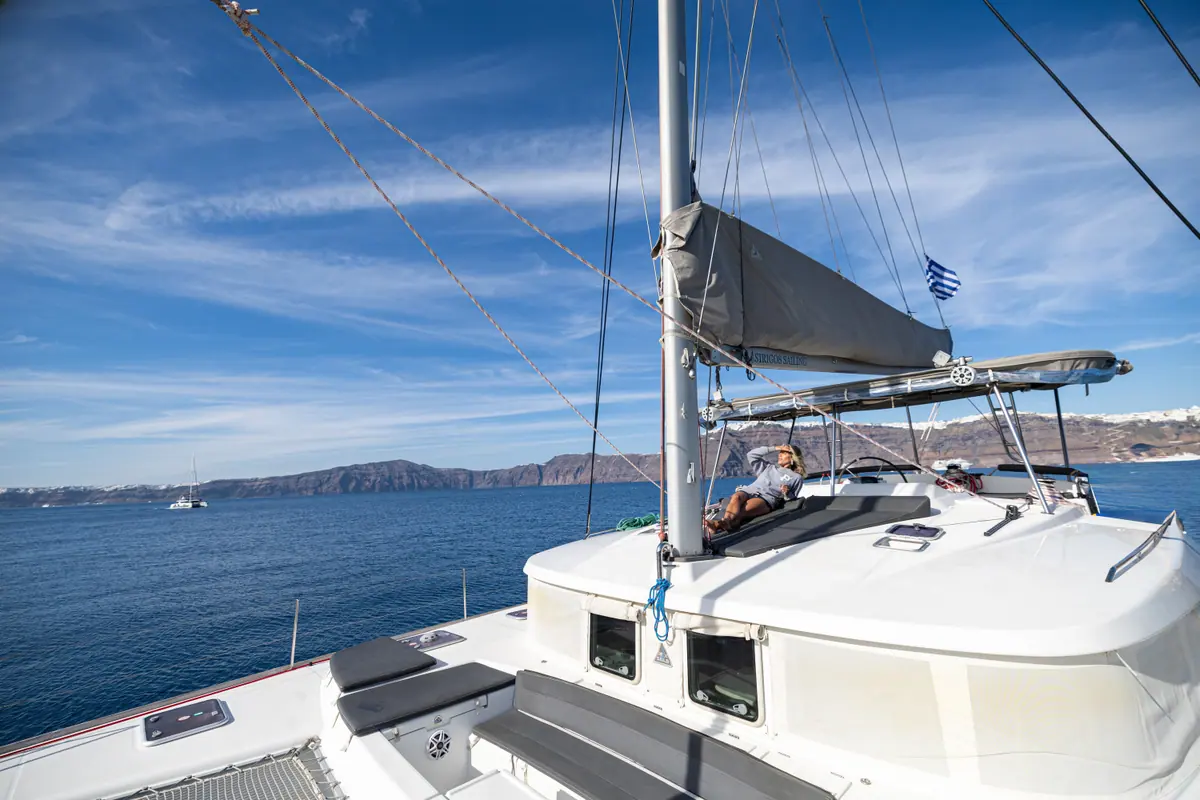 The catamaran’s empty foredeck and trampolines under sail, with nobody else aboard.