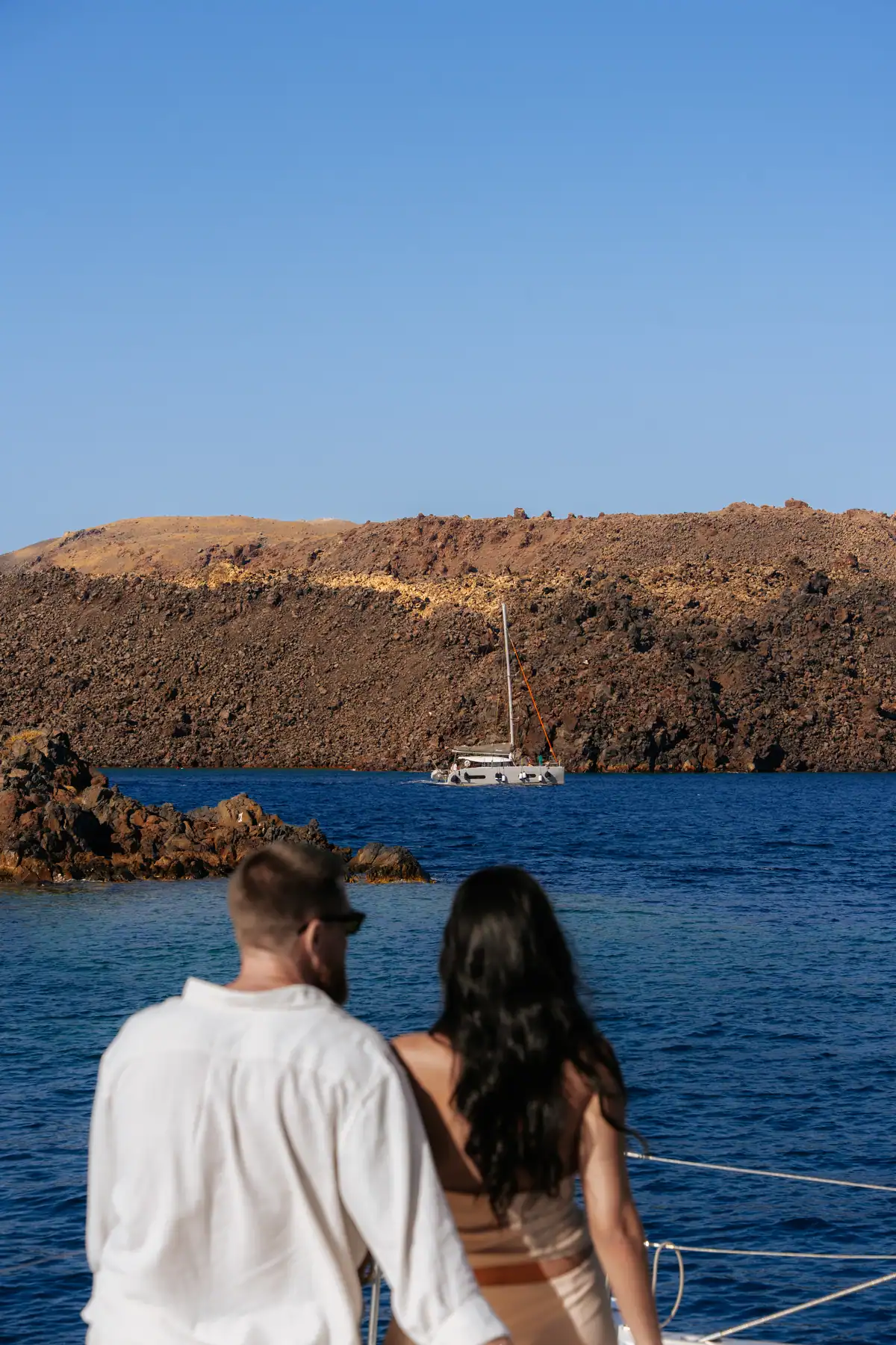 The caldera cliff wall with a boat lying at anchor beneath it.