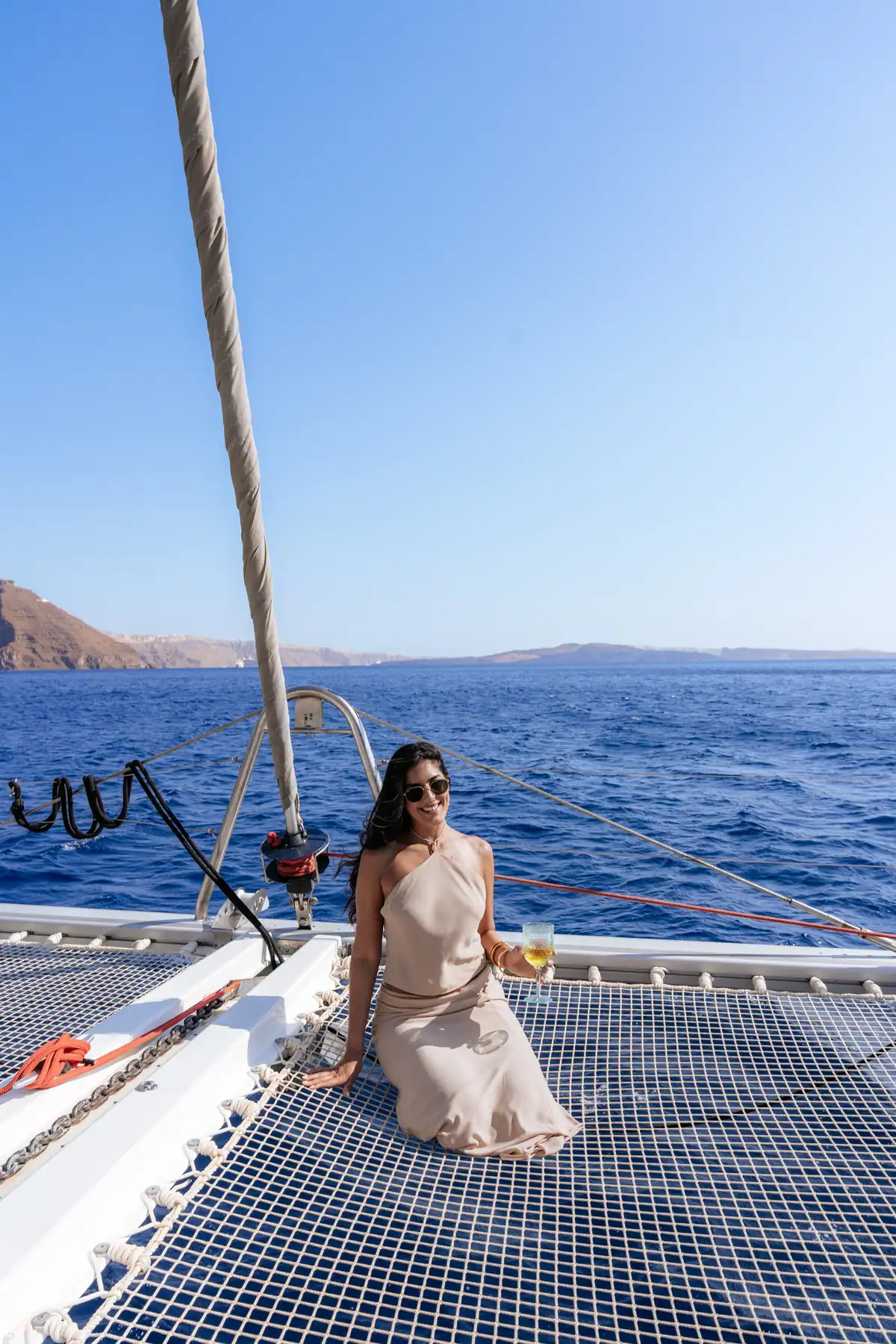 A guest on the foredeck with the whole caldera open ahead of the boat.